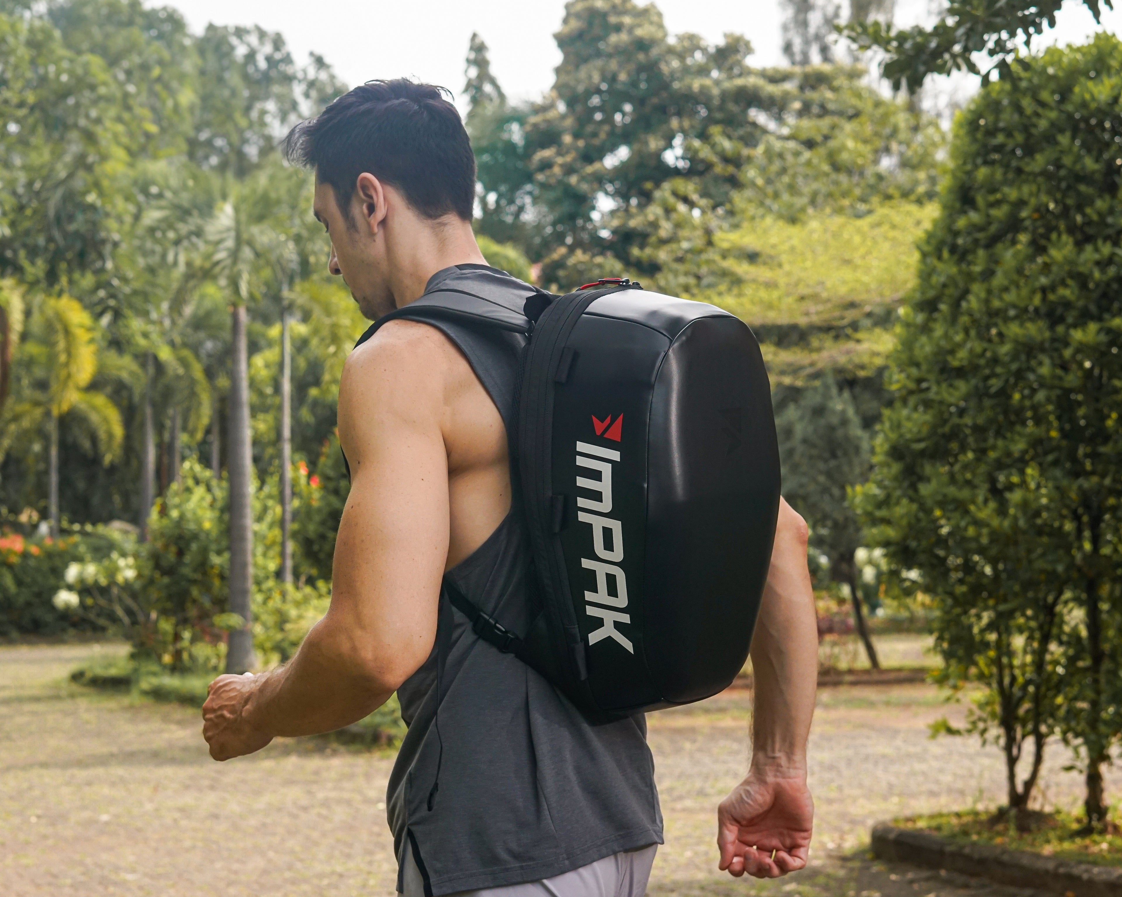 Man wearing ImPAK bag as a backpack running through a park